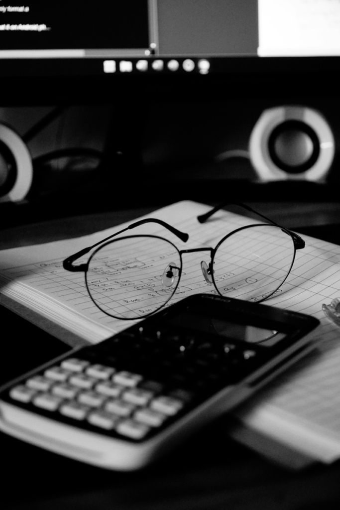 Calculatrice, lunettes et carnet de notes représentant la rigueur nécessaire à la gestion comptable des associations.