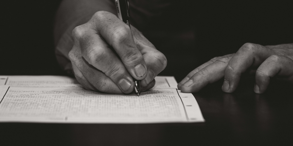 Une personne signant un document administratif, symbolisant l'engagement dans la gestion des obligations légales pour les associations.