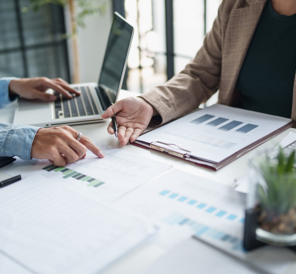 Une personne discutant des graphiques financiers et des documents comptables, symbolisant l'importance de bien comprendre les obligations fiscales et comptables des infirmiers libéraux.