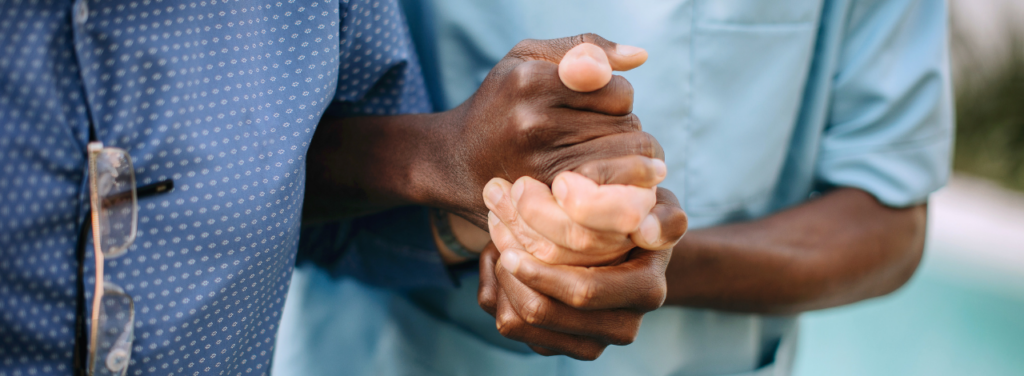 Deux mains qui se serrent avec douceur, symbolisant le soutien et la solidarité dans le cadre des soins infirmiers.