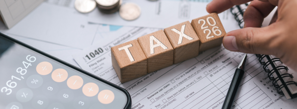 Blocs en bois avec inscription TAX 2026 sur documents fiscaux et calculatrice illustrant la fiscalité des dividendes