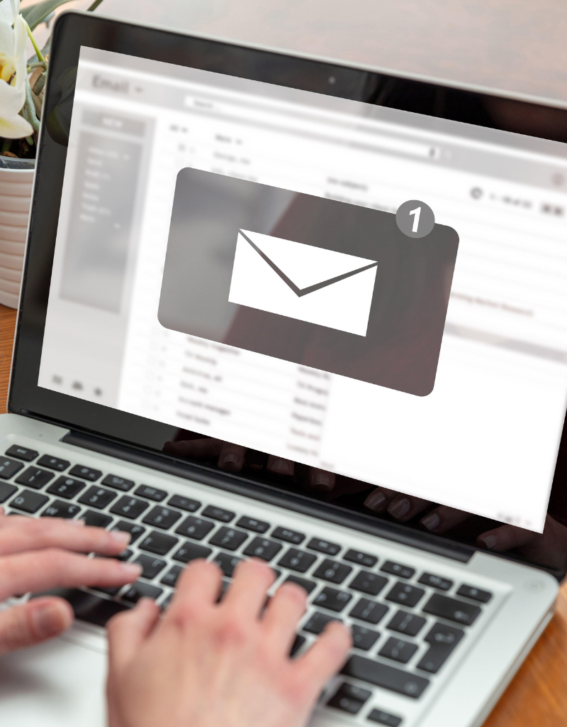 Image montrant une personne consultant ses emails sur un ordinateur portable, avec une notification d'email en attente.