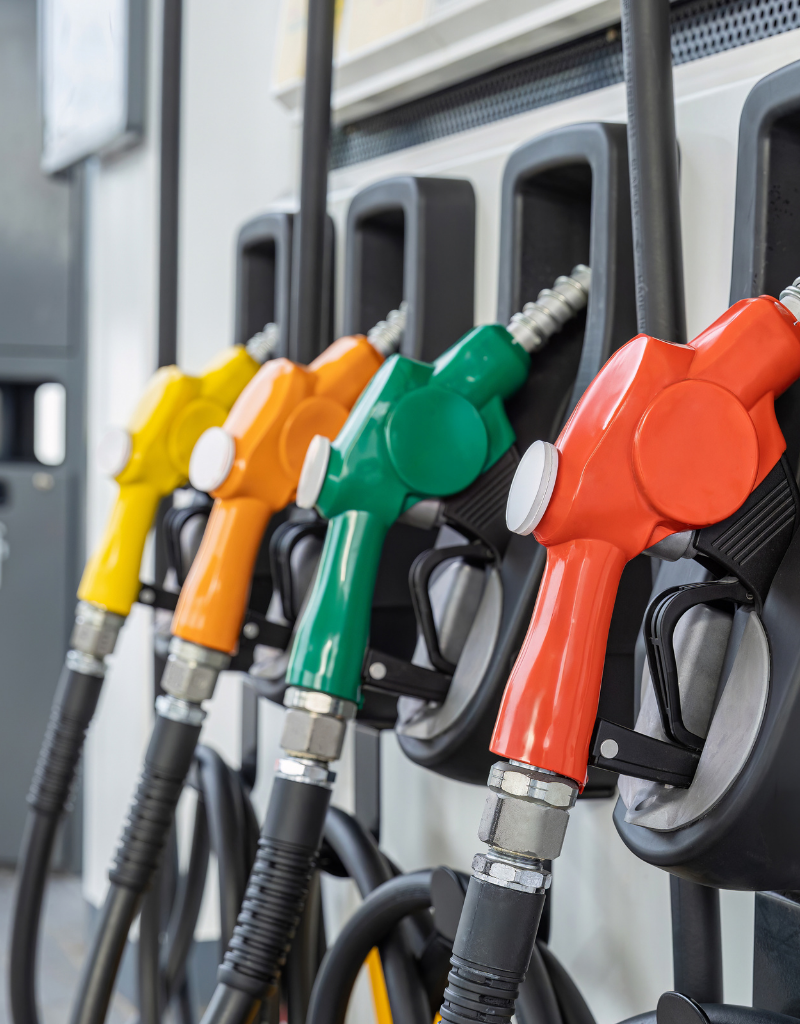 Pistolets de distribution de carburant colorés alignés dans une station-service.