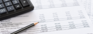 Calculatrice et crayon sur un document comptable illustrant le calcul du chiffre d’affaires.
