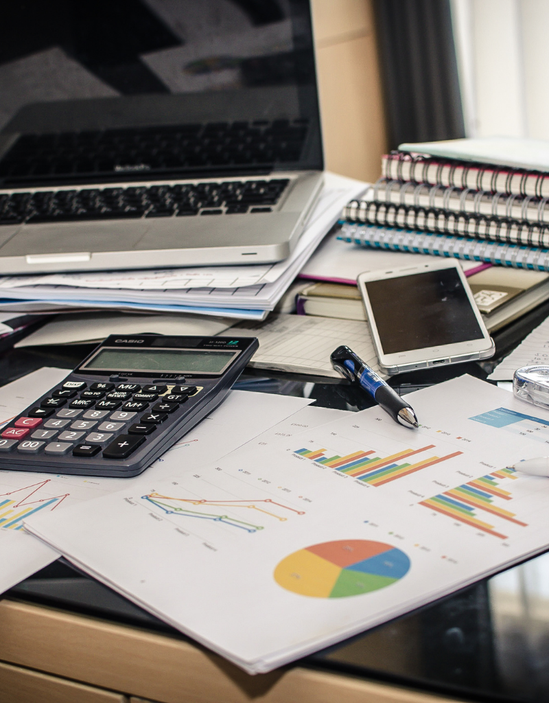 Ordinateur, calculatrice et graphiques financiers utilisés pour estimer le chiffre d’affaires prévisionnel d’une entreprise.
