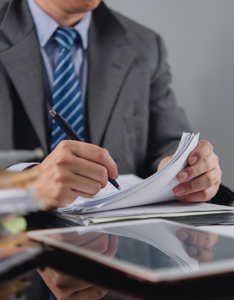 Professionnel vérifiant des documents administratifs, illustrant le numéro SIRET attribué à chaque établissement d’une entreprise.