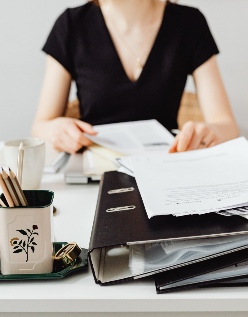 Professionnelle consultant des documents administratifs, illustrant le code APE qui identifie l’activité principale d’une entreprise.
