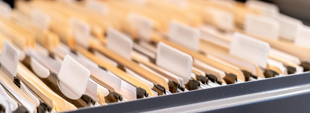 Dossiers administratifs classés dans un fichier, illustrant les documents et identifiants d’immatriculation d’une entreprise.